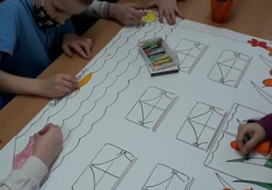 Uczniowie tworzą wspólną pracę plastyczną techniką rysunkową "Baśniowa szkoła"